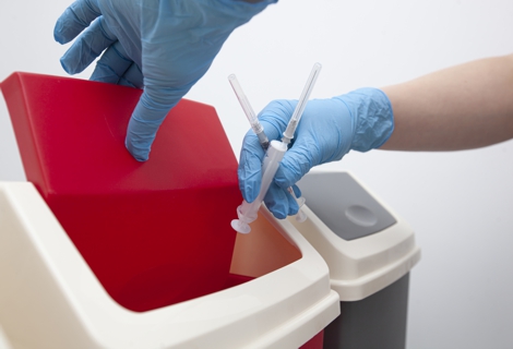 The nurse throw away used syringe into bin